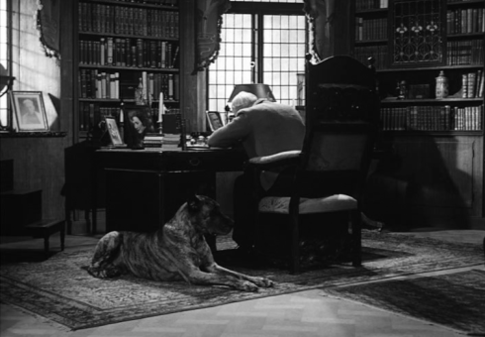 1. El profesor Isak Borg (Viktor Sjöström) sentado en su escritorio de trabajo, de espaldas